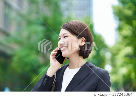 スマートフォンで通話するビジネスウーマン スマートフォンで通話するビジネスウーマン 137246364