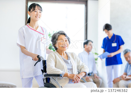 車椅子に乗るシニア女性と介護士 車椅子に乗るシニア女性と介護士 137246382