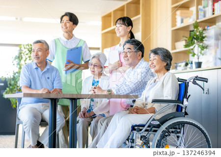 介護施設で寄り添う若いヘルパーとシニア 介護施設で寄り添う若いヘルパーとシニア 137246394