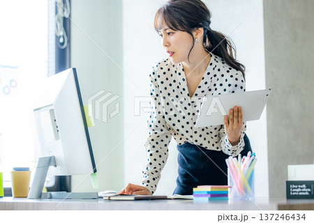 オフィスで仕事をする若い女性 137246434