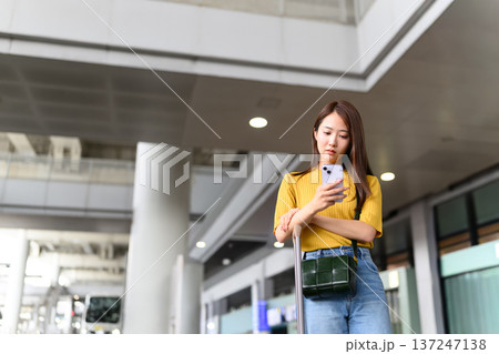 空港でスマホ操作する女性 ■撮影協力:関西国際空港(KIX) 空港でスマホ操作する女性 ■撮影協力:関西国際空港(KIX) 137247138