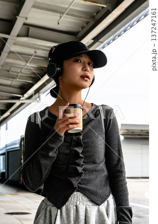 駅で音楽を聴く女性 ■撮影協力：関西国際空港（KIX） 137247161