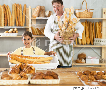 Baker dad and daughter are standing near product range in bakery kitchen. Baker dad and daughter are standing near product range in bakery kitchen. 137247432