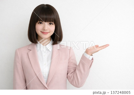 白壁の前に立ち御案内をするおかっぱボブの女性 4 137248005