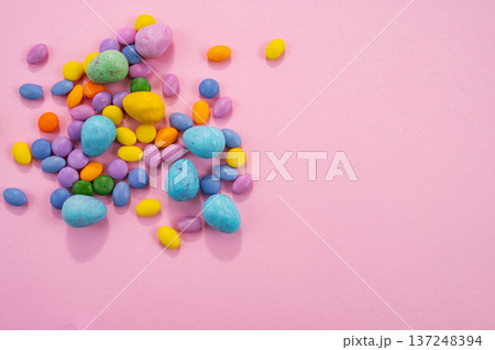Chocolate Easter eggs and colorful sweets on a pink background. Chocolate Easter eggs and colorful sweets on a pink background. 137248394