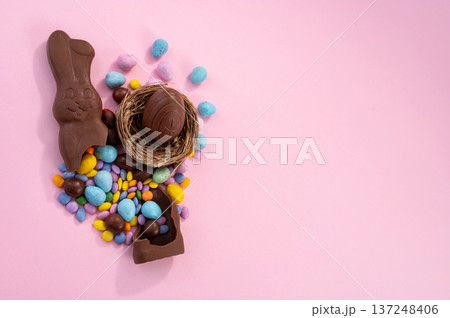 Chocolate Easter eggs and colorful sweets on a pink background. Chocolate Easter eggs and colorful sweets on a pink background. 137248406