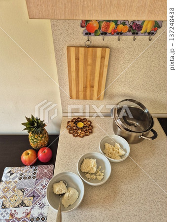 A composition of pineapple, apples, and kitchen utensils waiting to be prepared or served on a bright, modern table. 137248438