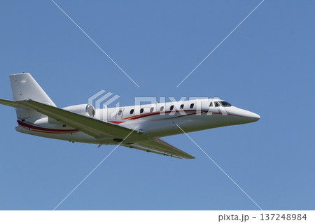 青空を飛行する小型プライベートジェット機 137248984