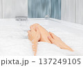 Close up hands of woman gently massaging her legs while soaking in a luxurious bubble bath, embracing wellness, hygiene, and self care in a spa like bathroom setting 137249105
