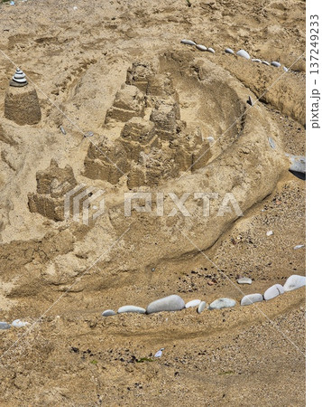 sandcastle on a sunny beach. creative sand sculpture. summer vacation fun sandcastle on a sunny beach. creative sand sculpture. summer vacation fun 137249233
