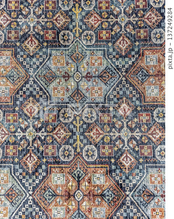 Vintage-style rug with a colorful, intricate Persian or Turkish ornamental pattern. Abstract background texture. 137249284