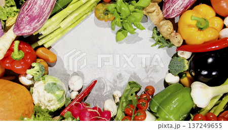 Fresh vegetables arranged in a circle on a gray surface at a kitchen setting during daytime with natural light 137249655