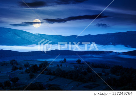 mountainous rural area during springtime at night. full moon over remote mountain landscape with forested rolling hills. mysterious foggy place of alpine countryside wallpaper 137249764