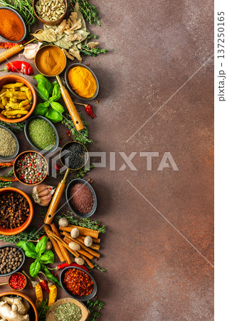 A harmonious mix of spices and herbs, bursting with colors and fragrances, spread on a warm brown background, evoking a sense of culinary artistry A harmonious mix of spices and herbs, bursting with colors and fragrances, spread on a warm brown background, evoking a sense of culinary artistry 137250165