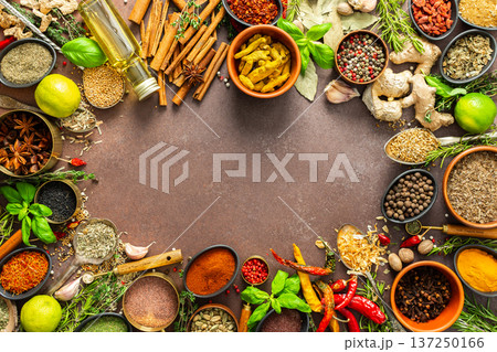 A diverse collection of vibrant spices and herbs, elegantly positioned on a brown backdrop, exuding natural beauty and a burst of fragrances, spice frame 137250166
