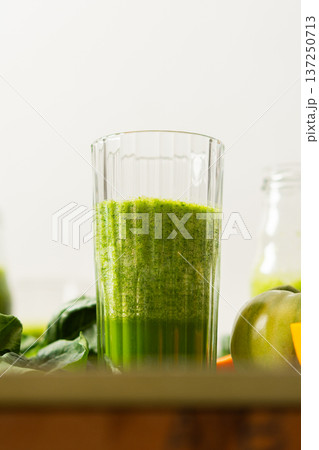 Fresh juice is made using spinach, chard, and broccoli along with oranges and tangerines. A glass of green juice sits by fresh ingredients on a clean kitchen counter Fresh juice is made using spinach, chard, and broccoli along with oranges and tangerines. A glass of green juice sits by fresh ingredients on a clean kitchen counter 137250713