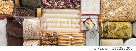 Home food supplies for quarantine and isolation, including canned food, cereals, pasta, and essential staples for survival, survival during military operations, the concept of stay at home, banner Home food supplies for quarantine and isolation, including canned food, cereals, pasta, and essential staples for survival, survival during military operations, the concept of stay at home, banner 137251200