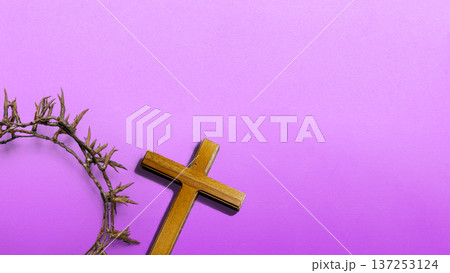 Religious Christian symbols of a wooden cross and crown of thorns on a textured purple background. Concept for Lent, Holy Week, Good Friday, and Easter themes with copy space for text 137253124