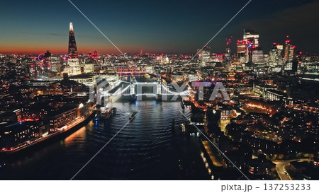 England, London: Illuminated London skyline at sunset, Tower Bridge over Thames River and The Shard in a stunning urban night lights. Aerial view drone flight over famous UK capital tourist landmarks England, London: Illuminated London skyline at sunset, Tower Bridge over Thames River and The Shard in a stunning urban night lights. Aerial view drone flight over famous UK capital tourist landmarks 137253233