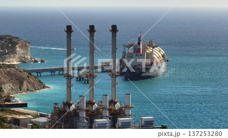 Malta: Aerial view of a liquefied natural gas tanker moored near a power station, highlighting the energy supply chain and infrastructure. Drone flight 137253280