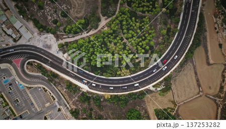 Malta: Cars driving scenic highway road with lush greenery and fields, breathtaking aerial perspective of the island's infrastructure traffic and natural beauty. Drone flight , top down view 137253282