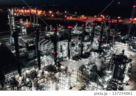 Oil refinery at night lit. Construction of an oil industrial fac Oil refinery at night lit. Construction of an oil industrial fac 137254061