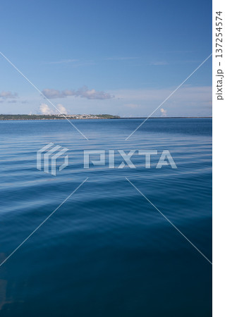 穏やかな青い海と水平線に浮かぶ遠くの島影 137254574