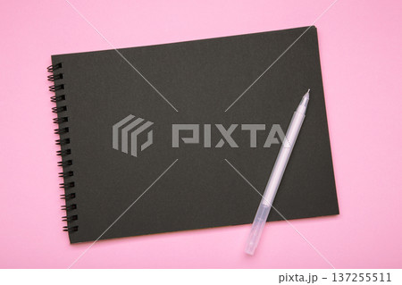 Black notebook with black pen on pink background. Mockup Black notebook with black pen on pink background. Mockup 137255511