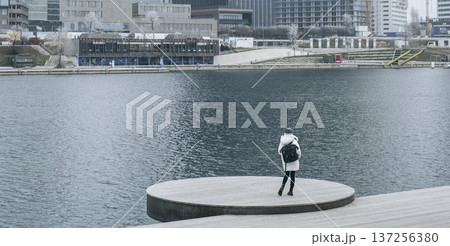 Solitary woman gazing at the urban waterfront from the platform 137256380