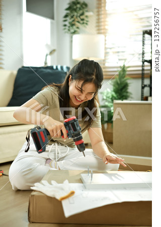 Woman is engaged in assembling the cabinet 137256757