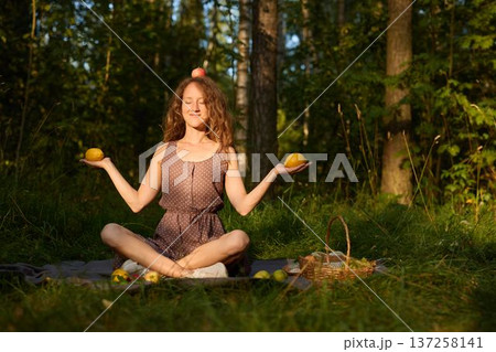 Woman enjoying sunny day gathering apples outside 137258141