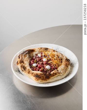 Rich stew with crispy accents, Smoky crust topped with creamy dots 137258218