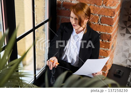 Attorney studying legal papers against brick background 137258230
