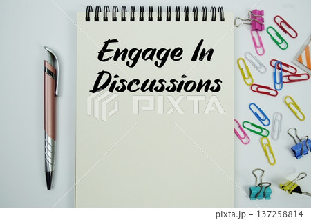 Engage In Discussions text message written on notepad with stationery flat lay on white background Engage In Discussions text message written on notepad with stationery flat lay on white background 137258814
