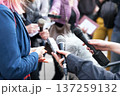 Public figure talking to the media, journalists holding microphones at press conference 137259132