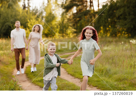 Brothers And Sisters Stroll Along Meandering Trail Amidst Open Nature With Happiness And Curiosity 137260819