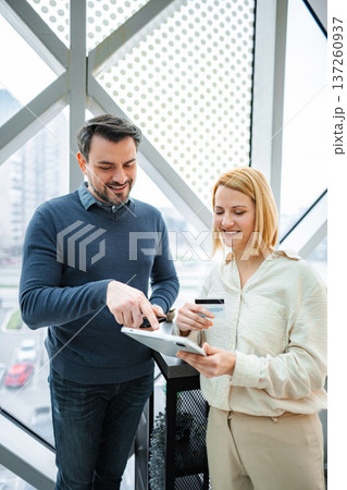 Business partners making online payment using tablet and credit card Business partners making online payment using tablet and credit card 137260937