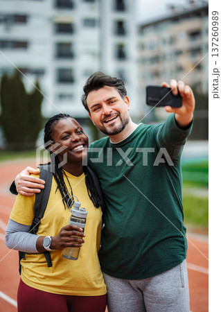 Happy interracial couple taking selfie on running track 137260989