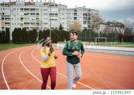 Diverse friends running together exercising on track Diverse friends running together exercising on track 137261307