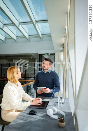 Business colleagues collaborating in office meeting with laptop and tablet 137261336