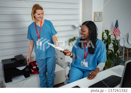 Nurses collaborating in office, working with patient paperwork 137261382