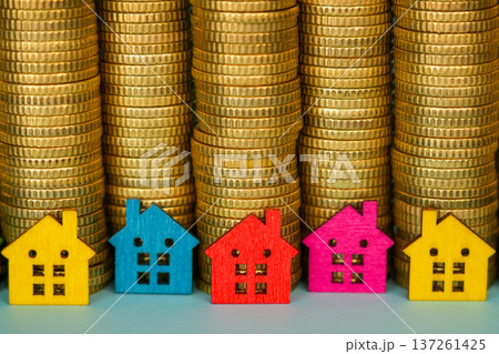 Colorful Miniature Houses in Front of Coin Stacks Real Estate Investment Concept 137261425