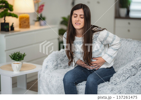 Woman experiencing sudden abdominal pain feeling stomach ache 137261475