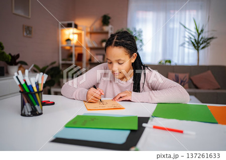 Girl drawing creative art on colorful paper at home Girl drawing creative art on colorful paper at home 137261633