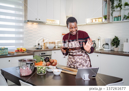 Woman enjoying video call while preparing healthy dinner Woman enjoying video call while preparing healthy dinner 137261677