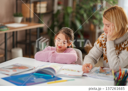Tired mother and child struggling with homework at home 137261685