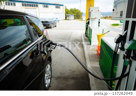 Car refueling at gas station pump with fuel nozzle Car refueling at gas station pump with fuel nozzle 137262049