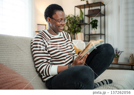 Happy woman reading book relaxing at home 137262056