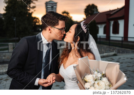 Biracial wedding couple kissing during romantic sunset ceremony 137262070