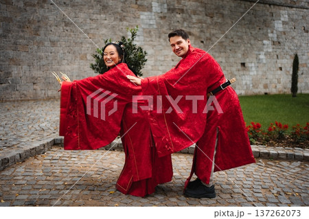 Smiling bride and groom posing in red traditional Chinese wedding attire Smiling bride and groom posing in red traditional Chinese wedding attire 137262073